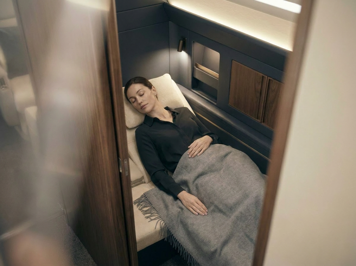 Rendering of a cabin space arranged for rest, with a wool throw and dark joinery